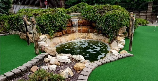 Artificial grass landscaping around a garden pond