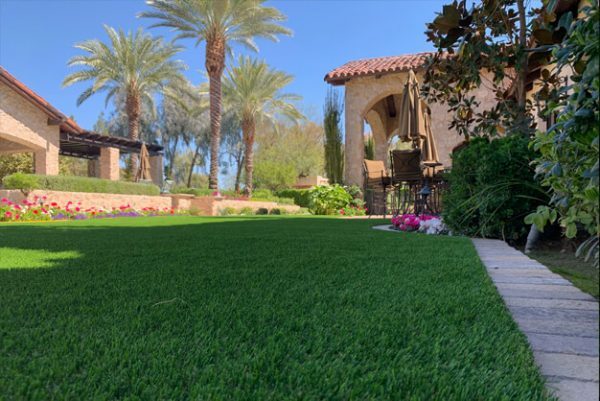 Finished artificial grass lawn beside a stone path